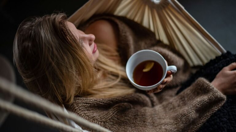 woman on hammock holding cup of coffee
