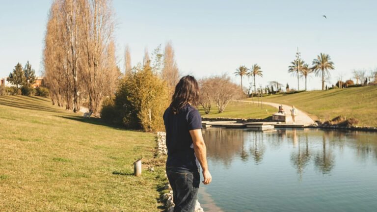 a man standing next to a body of water